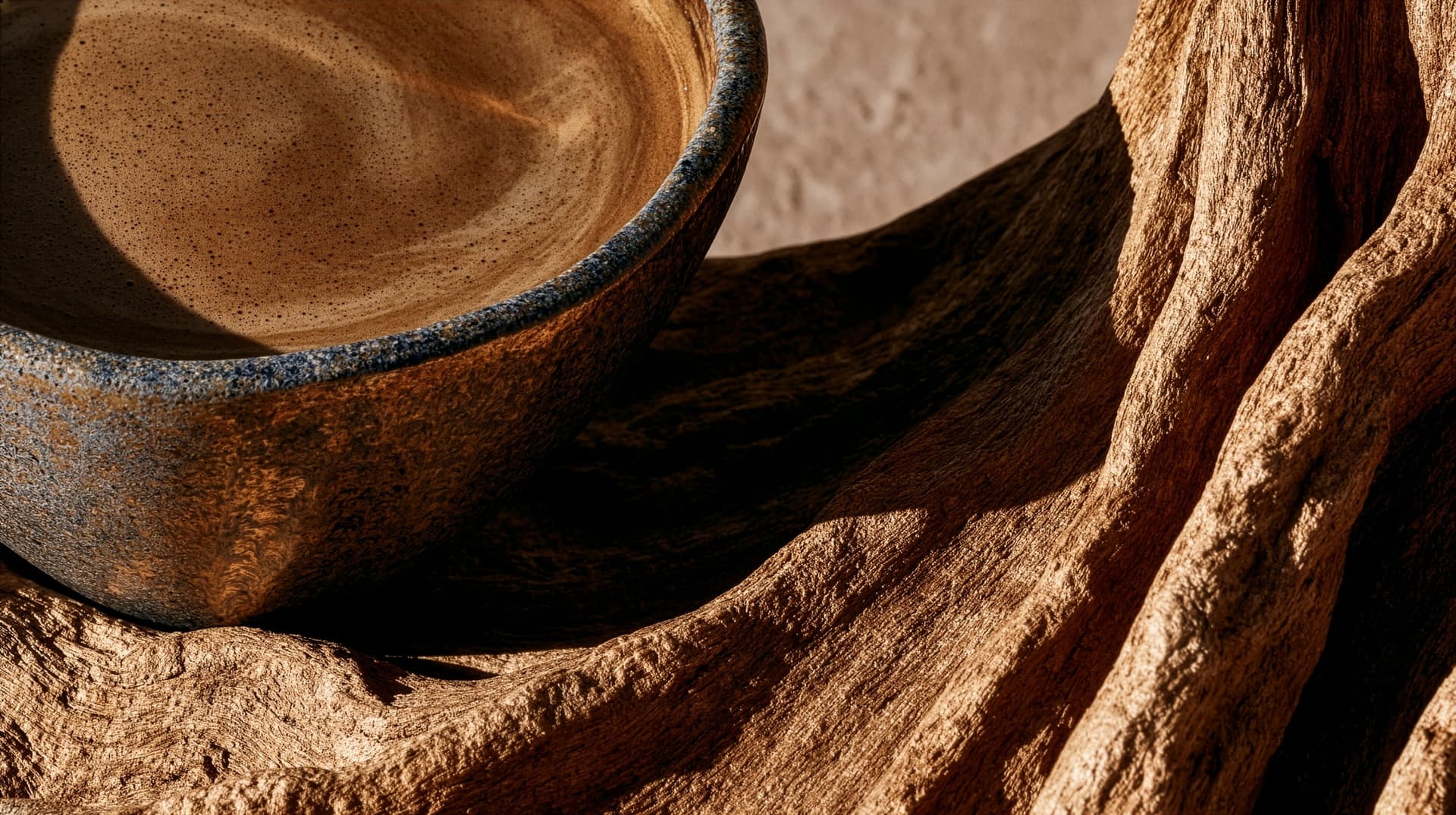 A brewed cup beside a wood branch, warm still life